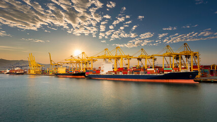 commercial port and container ship on the green sea over the sunlight clouds sky background