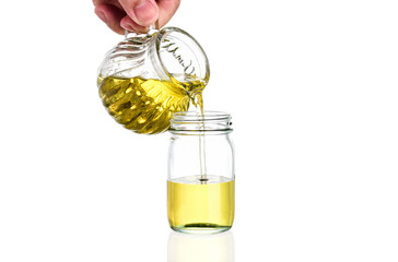 Chef is pouring natural organic vegetable oil made from flax seeds, sunflower, nuts, sesame and rice separately on white background.