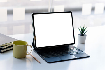 Fototapeta premium Office room with tablet blank white screen placed on the table.