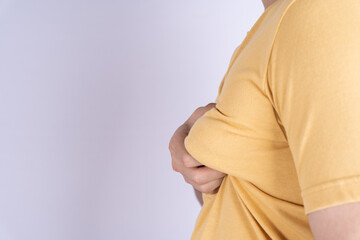 Fat man holding excessive fat boobs isolated grey background.