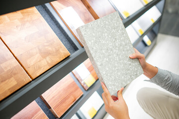 Male hand choosing stone cabinet panel materials or countertops for built-in furniture design....