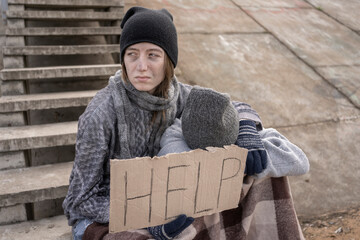 homeless mother with a child with a sign Help on the stairs in an abandoned place A homeless child...