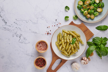 Pasta spaghetti with zucchini basil cream and cheese. Top view on stone table. Vegetarian vegetable pasta. Zucchini noodles. .Vegetarian cuisine. Homemade Brussels Sprouts roasted with olive oil.