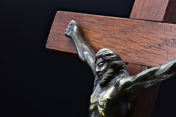 Jesus Christ crucifix ornament in closeup isolated on a black background