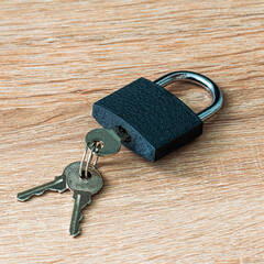 iron padlock with keys in the keyhole on a wooden surface concept prohibition security restriction