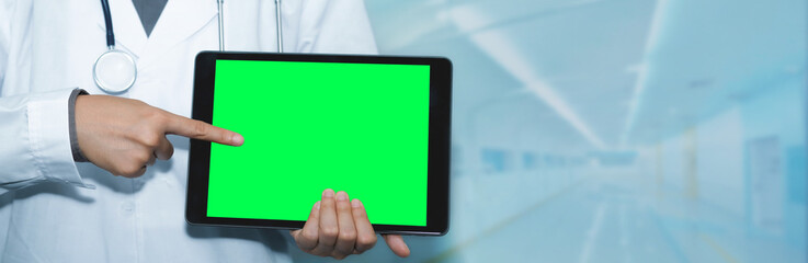 Doctor standing in clinic and using green screen tablet pc, hospital office for professional emergency healthcare assistance service concept, Doctor online, Online medical communication.
