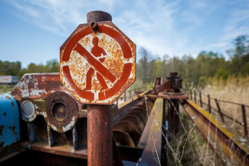 Fototapeta na wymiar antique rusty sign danger zone in Russian on the background of the old unit
