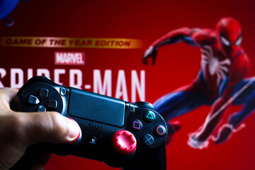 Naklejka premium May 17, 2021, Brazil. In this photo illustration the controller for PlayStation (PS) and in the background the game logo Spider-Man.