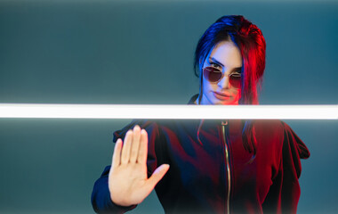 Stop discrimination. Neon light portrait. Feminist empowerment. Strict woman in sunglasses in red...