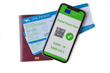 European Union digital green card with QR code on the mobile phone screen above the, passport. Immunity from Covid-19. Travel without restrictions