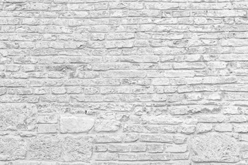 Old grungy retro bright brick wall of ancient city. Uneven clear pitted peeled surface brickwork of cellar worn. Ruined solid bumpy stiff blocks. Hard beautiful brickwall for 3D grunge minimal design