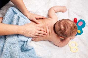 Little baby receiving chiropractic treatment of her back at home