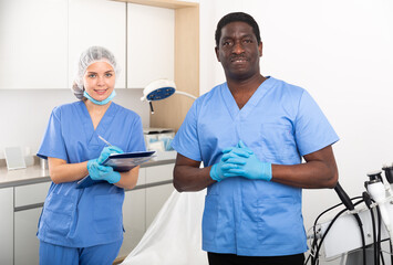 Obraz premium Two professional cosmetologists man and woman welcoming patient to aesthetic cosmetology clinic