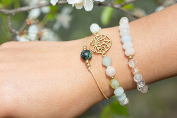 Female hand wearing popular gemstone mineral bead yoga bracelets