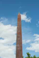 Iron obelisk with a small cross on a street in Madrid. Spain