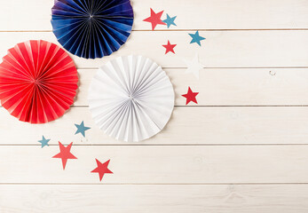 Decorations for 4th July, Independence Day USA. Paper fans and stars on white wooden background