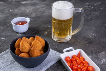 Traditional Brazilian fried snack stuffed with chicken and a glass of beer. Coxinha