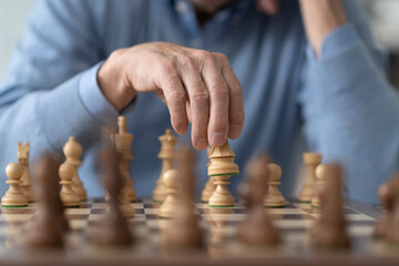Elderly man playing chess at home