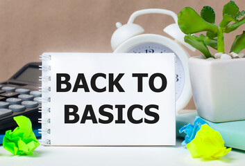 Flower in a pot, calculator, white alarm clock, multi-colored pieces of paper and a white notebook...