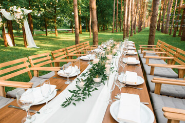 Rustic green branch and candles on the table. Wedding decoration.