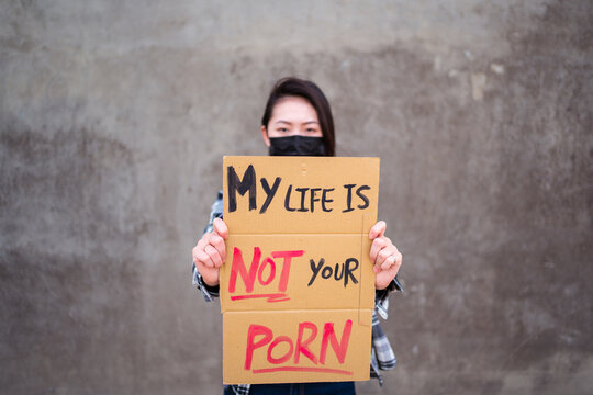 Ethnic female in protective mask standing with My Life Is Not Your Porn carton poster during protect against sexual harassment and assault