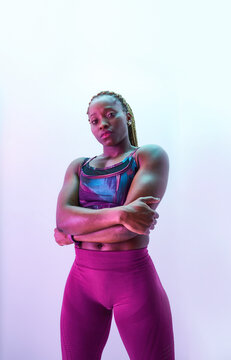 Self assured African American sportswoman in activewear with folded arms and biceps looking at camera