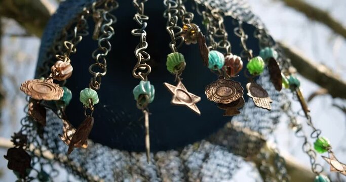 Low angle shot of charms with hamsa hand symbols hanging and moving slightly on the wind.