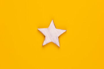 Fototapeta premium Christmas star decor on yellow colored background.