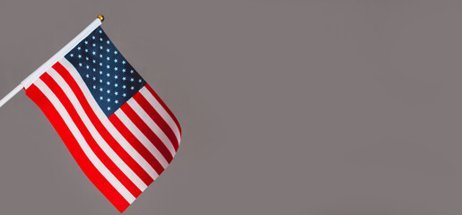 Banner Miniature flag of America is isolated on a gray background. Politics, learning a foreign...
