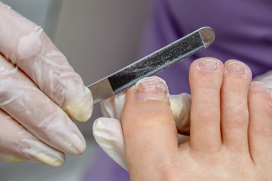 Women's pedicure in the salon. Processing the nail with a manicure file. Foot hygiene in the summer.