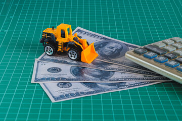Construction vehicle on dollar banknote money. Financial concept.