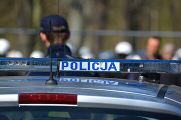 Niebieskie światła błyskowe policji. Napis policja na radiowozie polskiej policji. 