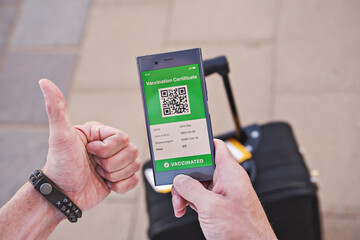Smartphone in hand displaying on app mobile valid digital green vaccination certificate for Covid-19. Immunity vaccine passport, vaccination certificate, health passport for new normal travel