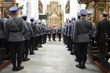 Polska policja w galowych mundurach na uroczystości w kościele. 