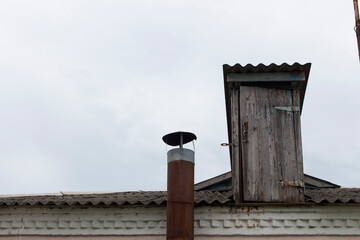 old gray attic with door on the roof of the house