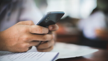 Students are test exam and study online by using smartphone in classroom
