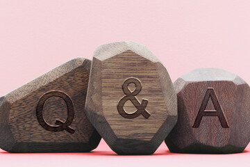 Letters Q&A written on wooden irregular blocks. Questions and answers concept.