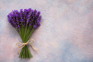 Bouquet a bunch of lavender flowers tied with a rope on a decorative colored background, space for text