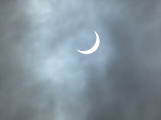 Obraz na płótnie Canvas Luna brillando en un cielo oscuro - cielo negro oscuro por la noche - nubes que cubren la luna - eclipse - media luna
