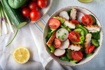 Grilled chicken breast, fillet and fresh vegetable salad of lettuce, spinach, cucumber and tomato
