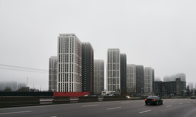 Fototapeta premium Smooth fog in Kyiv Ukraine Osokorky district. Skyscraper during moody weather