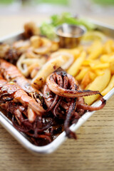Arrangement of seafood appetizers on plate. Includes shrimp, lobster and fish meat on skewer with vegetables.