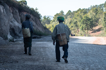 Two local burmese men walk down a gravel road, Myanmar