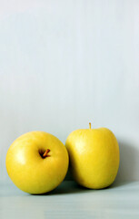 Two green apples on a gray background, juicy fruit, healthy food