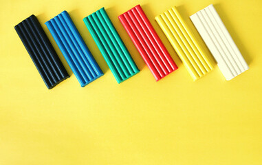 Plasticine of colorful colors on a bright yellow background, mold with plasticine 
