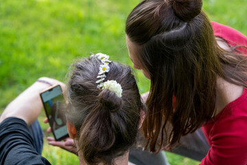 un jeune couple aux cheveux longs qui regarde des images sur un téléphone portable
