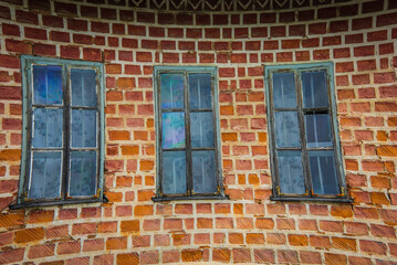 Fototapeta na wymiar Three old windows in the nave of an abandoned brick monastary in Bulgaria