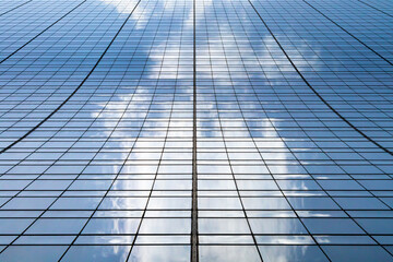 Tall modern skyscraper building with clouds reflected in the glass windows in Manhattan New York City NYC