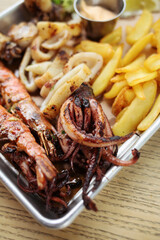 Arrangement of seafood appetizers on plate. Includes shrimp, lobster and fish meat on skewer with vegetables.