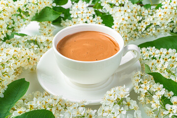 A cup of coffee close-up among the flowers.